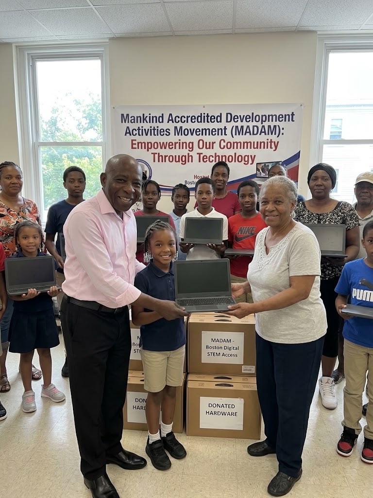 Community members and children gathered with laptops and donated hardware at a MADAM event